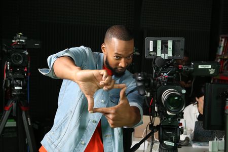Keon Poole pretending to be frame a shot next to video equipment. (National Geographic/Robert Toth)
