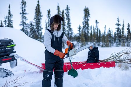 Ricko DeWilde using a chainsaw to cut a hole through the ice to set a beaver trap. (BBC Studios Reality Productions/v)