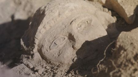 An unearthed stone head is revealed in the active citadel excavations in Amman, Jordan. (Windfall Films/Alex Collinge)