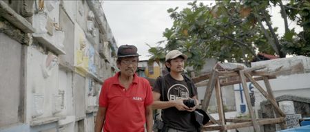 Manila, Philippines - Raffy Lerma walks with a man through a graveyard. (Genius Loki Film and Violet Films/Alexander A. Mora)