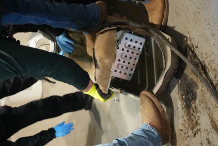 Multiple CBP officers work to dismantle the gas tank of a suspect's vehicle after packages of suspected narcotics were seen on a camera scope in Calexico, Calif. (National Geographic)