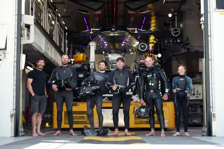 Aldo Kane with dive team James Loudon, Dave Reichert, Stephen Hudson, Nuno Sa and Emma Hatherley holding underwater cameras in the Sub Hangar. (National Geographic/Mario Tadinac)