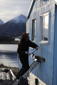 Marvin Agnot repairs the side of his home. (National Geographic/Lauren Bird Dixon)