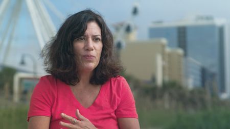 Karren Sites, shark attack survivor being interviewed on the beach and recalling her incident with a shark. (National Geographic)