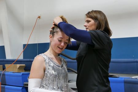 Dr. Erin Schroeder helps a student with her hair in preparation for the Wynot school's production of Little Shop of Horrors. (National Geographic)