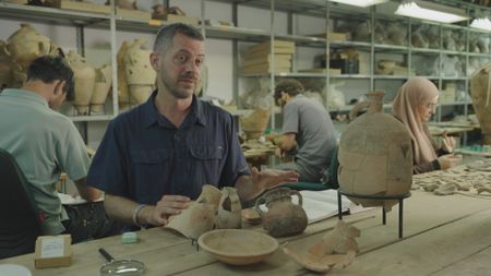 Ido Koch looks over previously found artifacts at the Tel Aviv University in Tel Aviv, Israel. (Windfall Films/Nava Mizrahi)