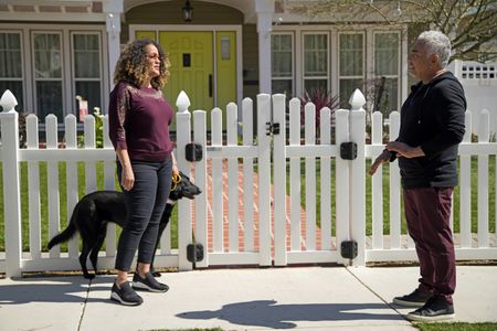 Bo holds her dog Shadow on leash while talking to Cesar. (National Geographic)