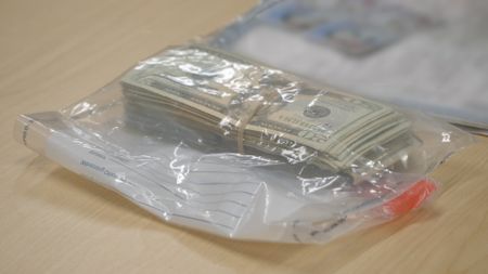 A stack of undeclared currency was placed in an evidence bag on an inspection table after it was found in a suspect's belongings in El Paso, Texas. (National Geographic)