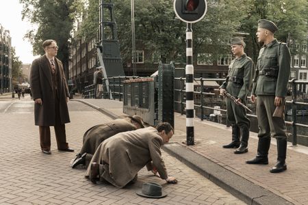 A SMALL LIGHT - Jan Gies, played by Joe Cole, confronts Nazi soldiers in the streets of Amsterdam, as seen in A SMALL LIGHT. (Credit: National Geographic for Disney/Dusan Martincek)