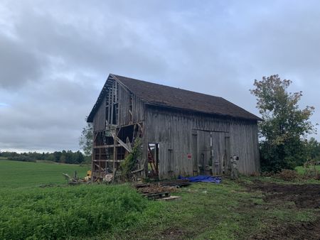 A crew member films the old barn the Pol family plans to take down to transport and restore on the Pol family's farmland. (National Geographic)