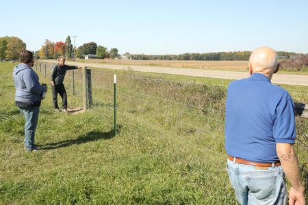 Charles Pol, Ben Reinhold, and Dr. Pol walk the Pol family farm's fence line to inspect the poles and wires that need to be repaired. (National Geographic)