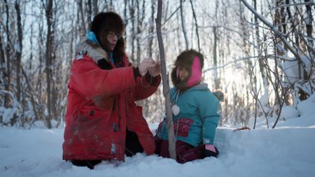 Ricko DeWilde shows his daughter Maya how to set rabbit snares. (BBC Studios/Ryan Walsh)