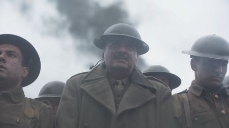 Major Akbar Khan (played by Jack Gill) walks with soldiers while smoke from explosions is seen behind them in a WW2 historic reenactment scene for "Erased: WW2's Heroes of Color." They finally are getting evacuated, and they orderly wait for their turn to board the ships. Major Akbar Khan was the most senior Indian in the British Army during WW2 and a member of Force K6, a little-known Indian regiment of mule handlers. Amidst the chaos of Dunkirk and the advancing German Army, the Indian regiment fought for victory and independence. (National Geographic)