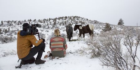 Clare and the cameraman with horses on a snowy hill. (Big Wave Productions)