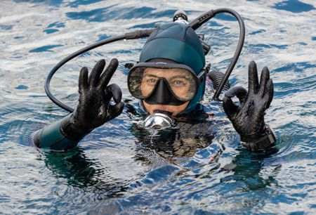Storyteller and cephalopod expert, Dr Alex Schnell, in full SCUBA gear, gives the 'ok' sign on the surface.   (photo credit: National Geographic/Harriet Spark)