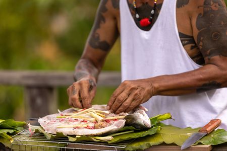 Peter prepares Ikan Semah for Henry Golding and Antoni Porowski. (Credit: National Geographic/Annice Lyn)