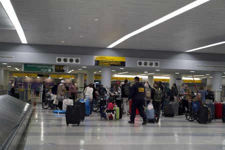 Multiple travelers wait for their luggage at baggage claim at the JFK International Airport, in New York. (National Geographic)