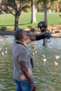 Christian Cooper holds out his arm for Bond, a trained Harris’ Hawk, to land on the gauntlet after successfully dispersing the troublesome black-crowned night heron population at a park in Palm Desert, CA. (National Geographic/Jon Kroll)