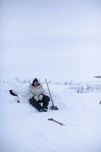 Agnes Hailstone shovels snow to help set up their family camp in Kiwalik. (BBC Studios Reality Productions/Ashton Hurlburt)